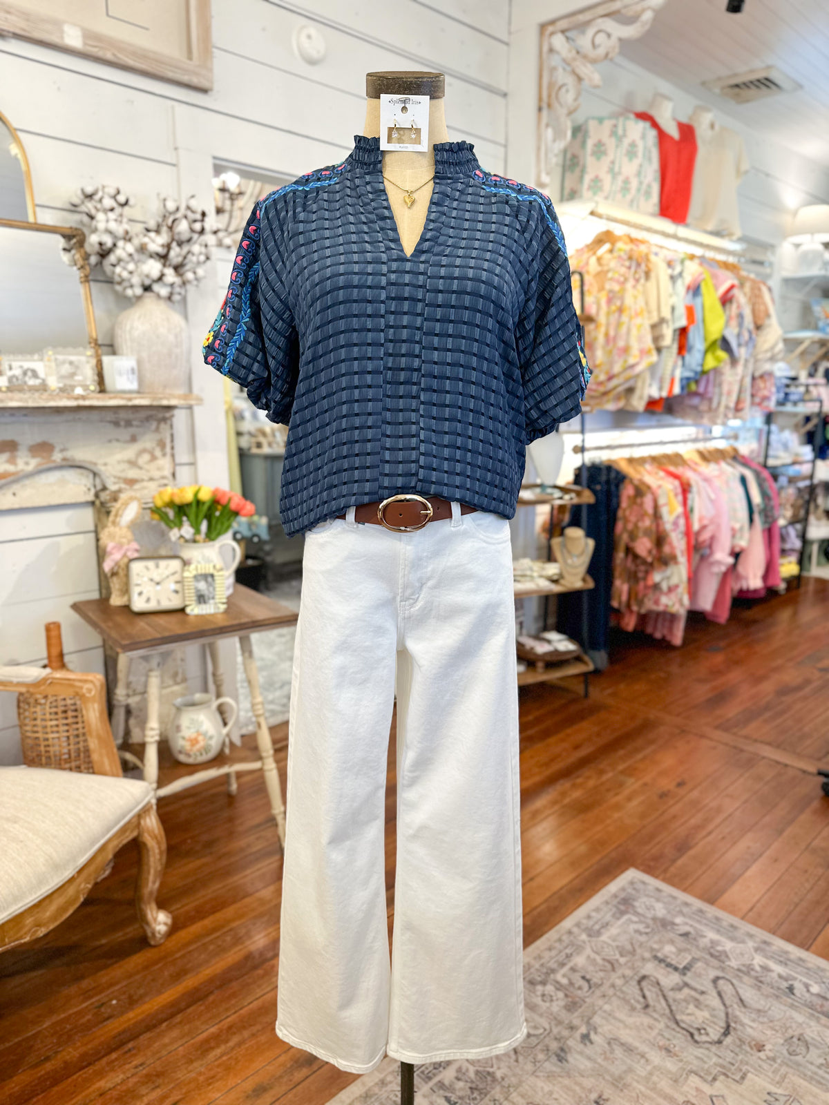 Mannequin wearing a blue textured shirt and white pants in a store setting