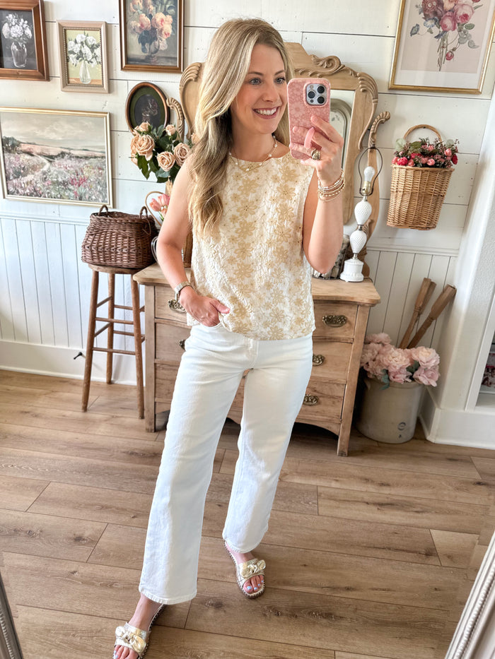 Woman taking a mirror selfie in a room with wooden floors and decorative items.