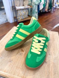green sneaker with yellow details on the side 