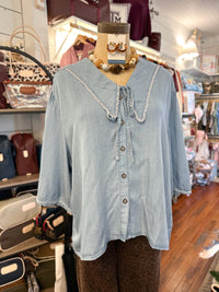 light blue peter pan collar blouse in store setting 