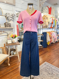 Mannequin wearing a pink top and blue pants in a store setting