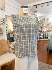 Black and white checkered top on a mannequin in a store setting