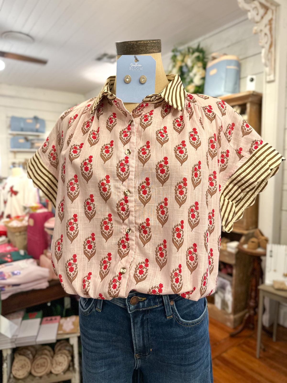 block print floral blouse with stripe details on the sleeves inside store setting 