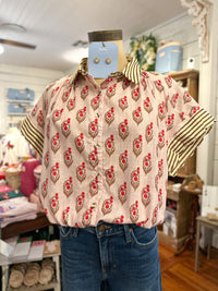 block print floral blouse with stripe details on the sleeves inside store setting 