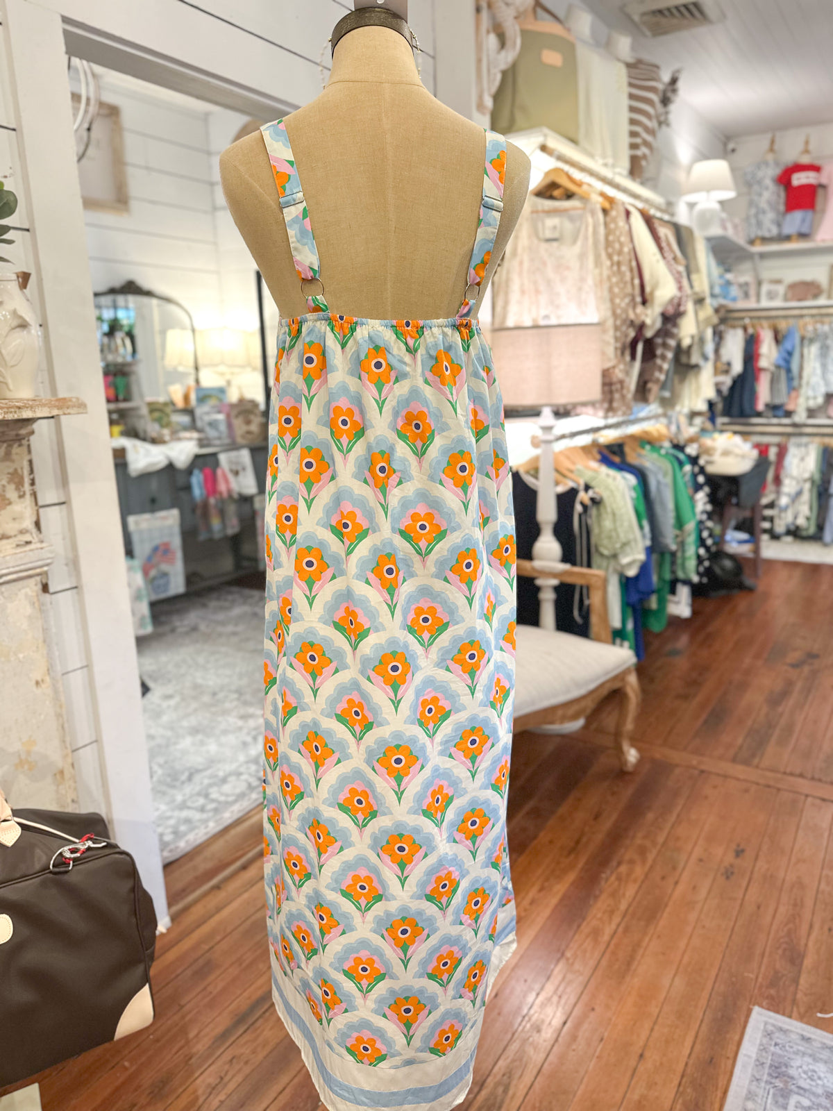 Mannequin wearing a floral dress in a store setting back of dress