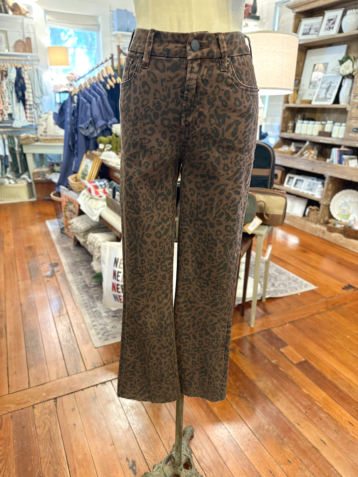 Brown and black leopard print wide-leg jeans displayed on a mannequin in a retail store.