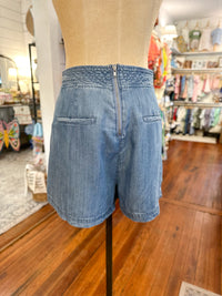 Blue denim shorts on a mannequin in a store setting back of skort 