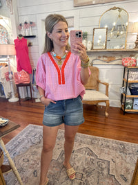 Woman taking a mirror selfie in a room with decor and furniture.