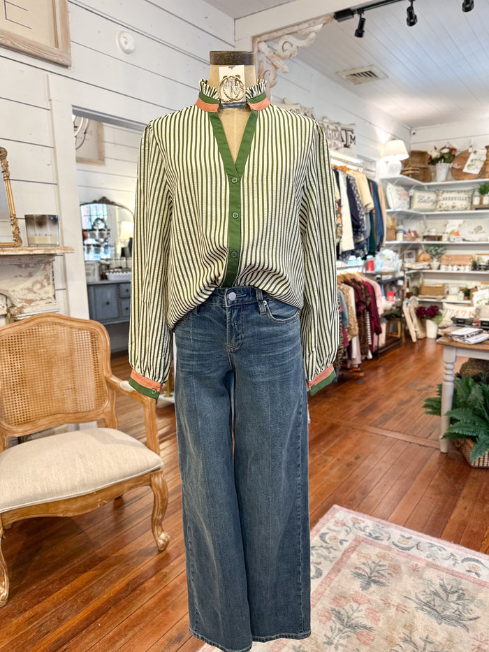 Mannequin wearing a striped shirt and jeans in a store setting