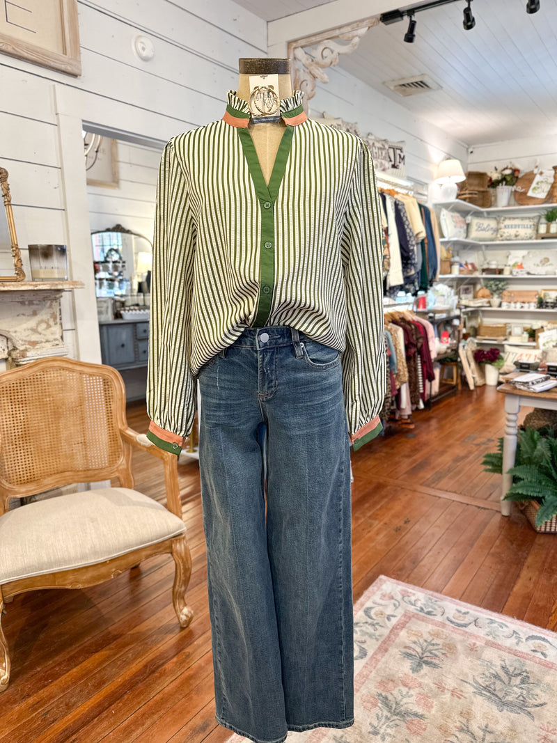Mannequin wearing a striped shirt and jeans in a store setting