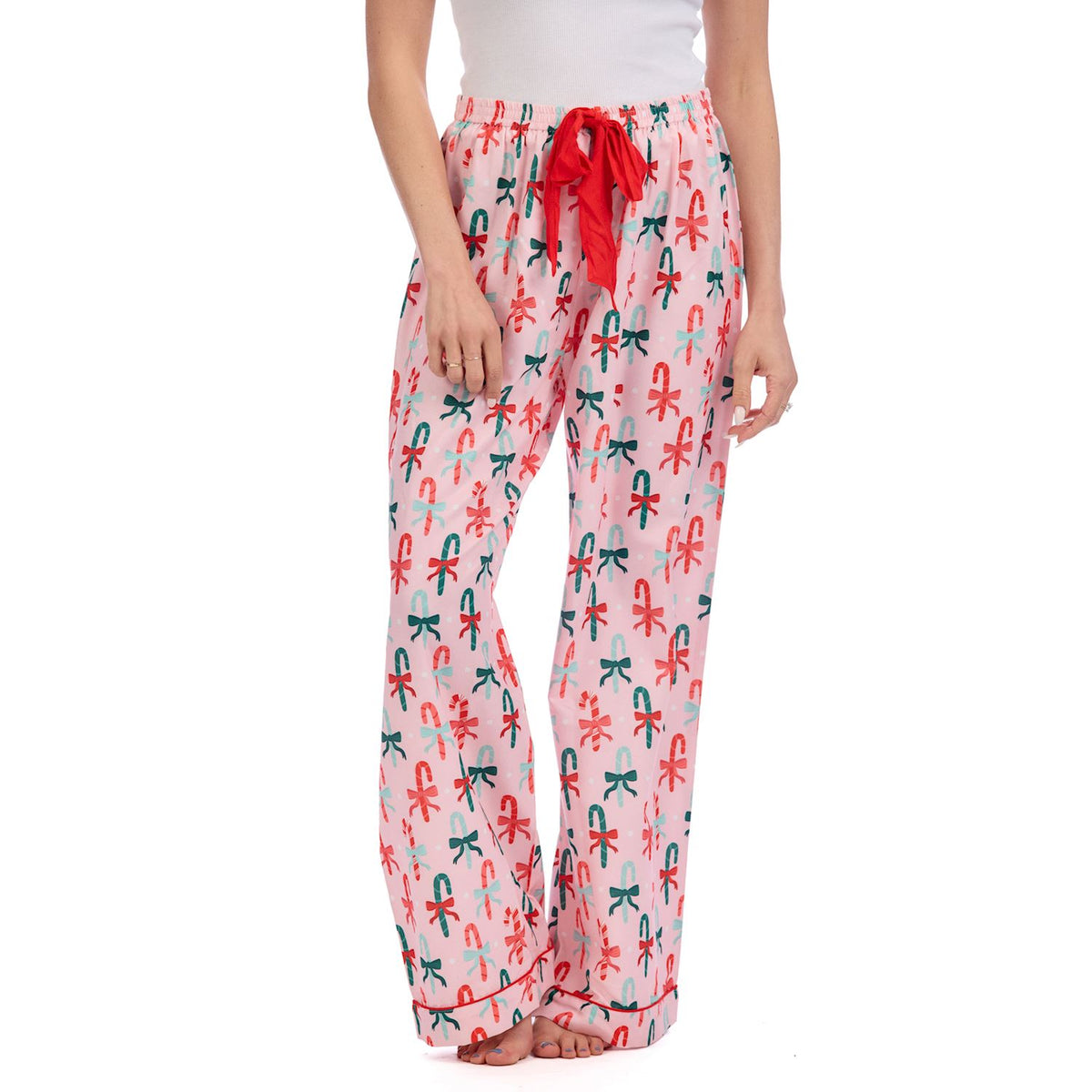 Pajama pants with candy cane and bow pattern on a white background