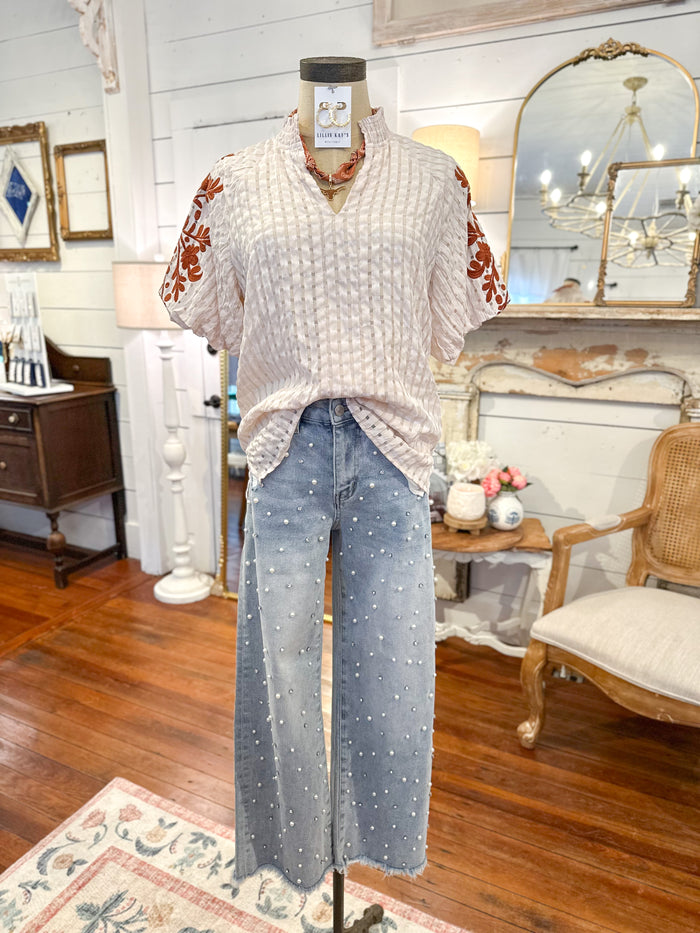Mannequin wearing a patterned top and jeans in a room with wooden floors and decorative elements. havannah top layerz clothing 
