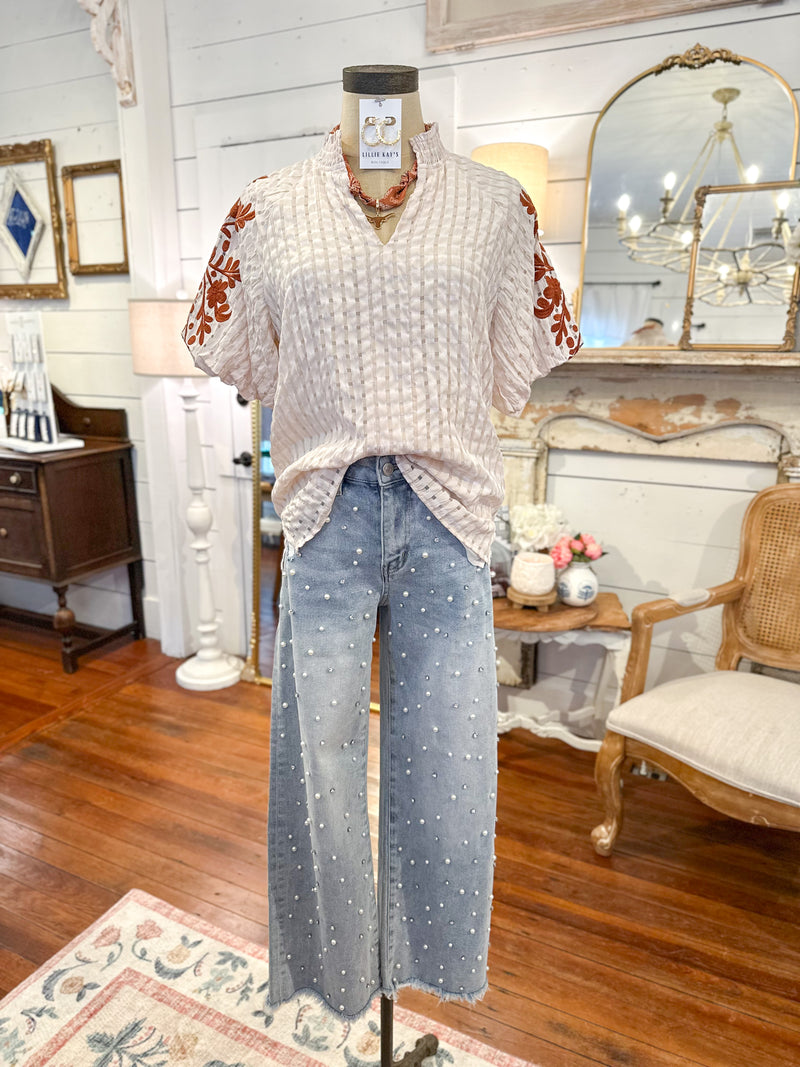 Mannequin wearing a patterned top and jeans in a room with wooden floors and decorative elements. havannah top layerz clothing 