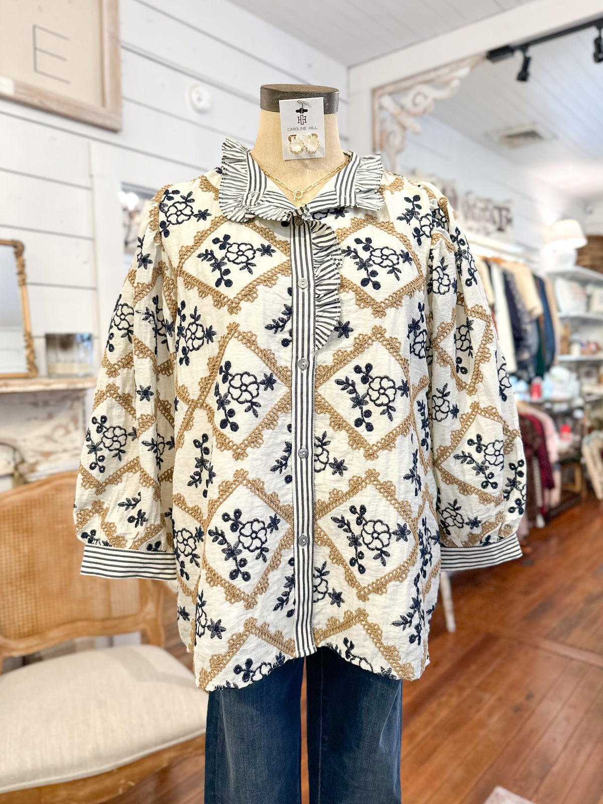 Mannequin wearing an embroidered top   in a store setting