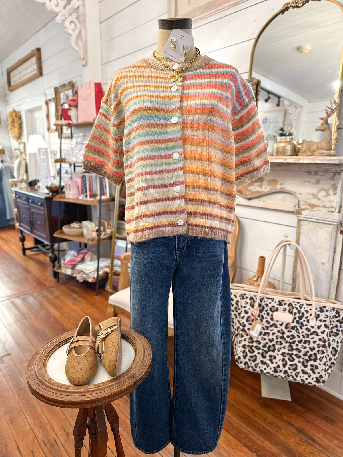 colorful short sleeve cardigan top with buttons and barrel jeans paired with brown flats
