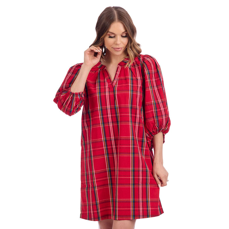 Woman wearing a red plaid dress on a white background