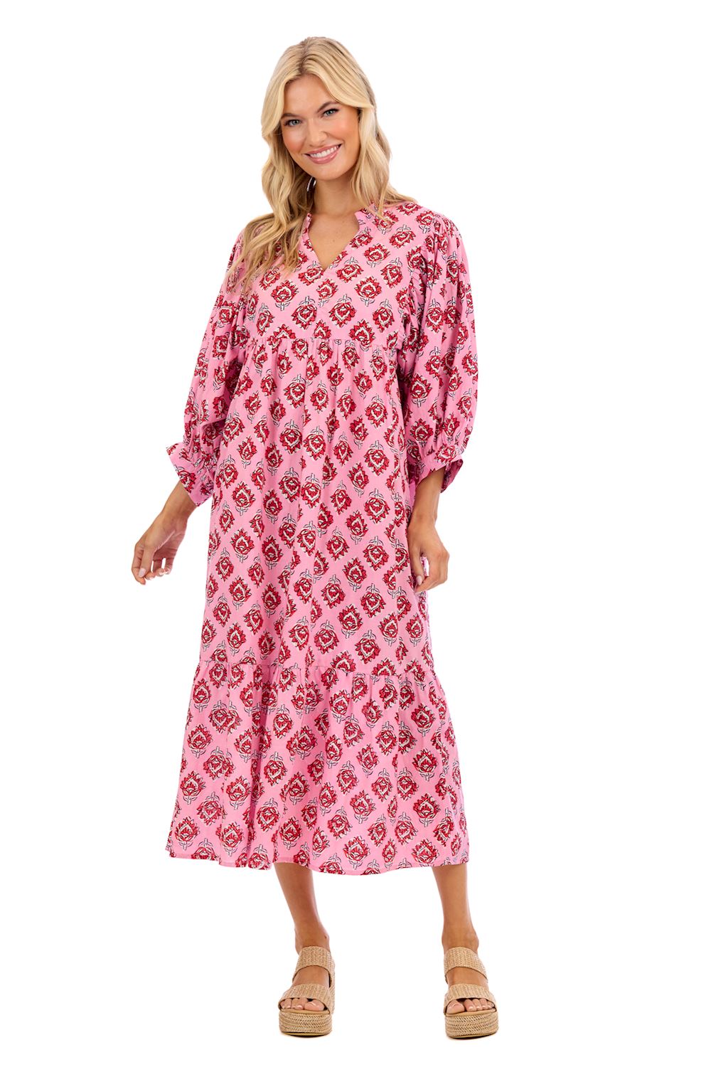 Woman wearing a pink patterned dress on a white background mud pie waylon dress