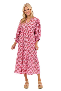 Woman wearing a pink patterned dress on a white background mud pie waylon dress