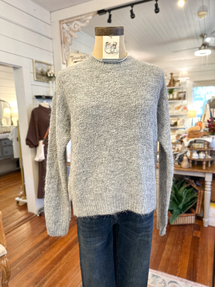 Gray sweater on a mannequin in a store setting
