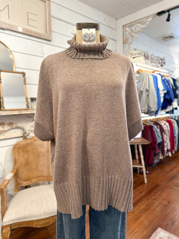 Brown turtleneck sweater on a mannequin in a store setting