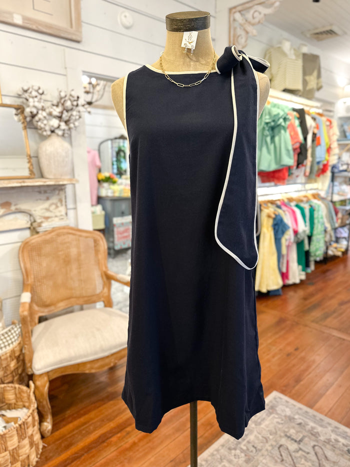 Navy dress with white trim on a mannequin in a store setting