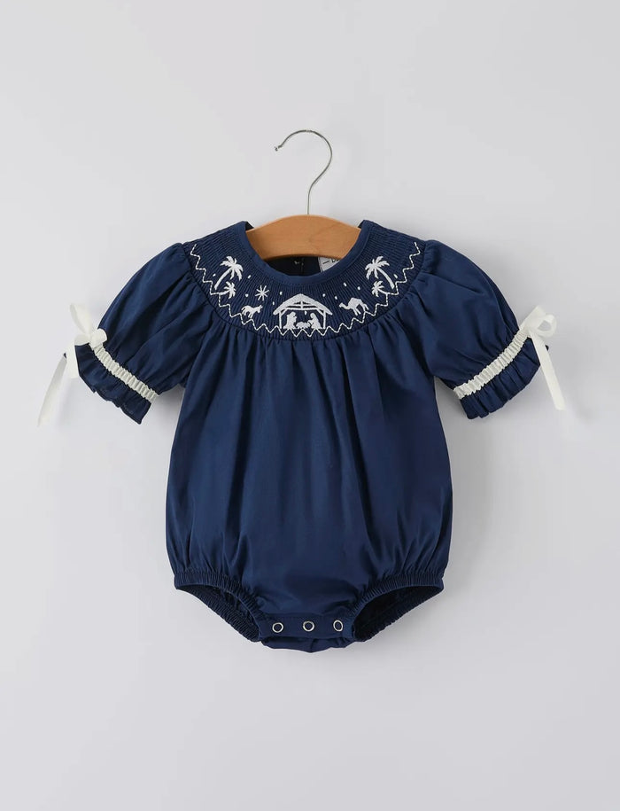 Navy blue baby romper with white embroidery on a hanger against a light gray background