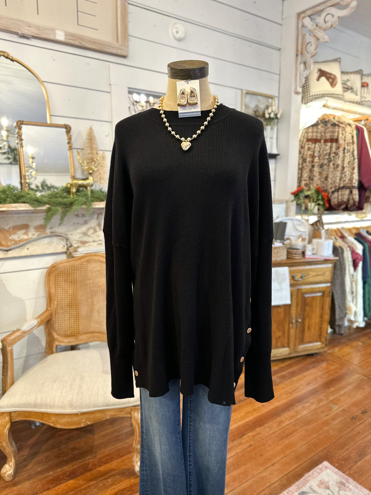 Black sweater on a mannequin with blue jeans in a store setting
mud pie noralee sweater