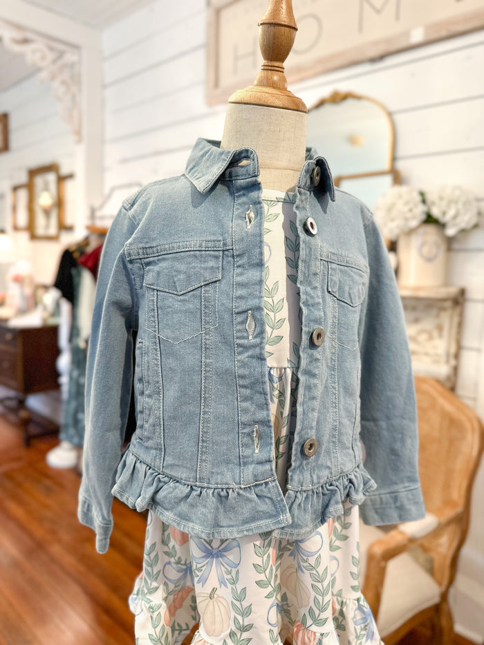 Denim jacket with ruffled details on a mannequin in a store setting for toddler girl 