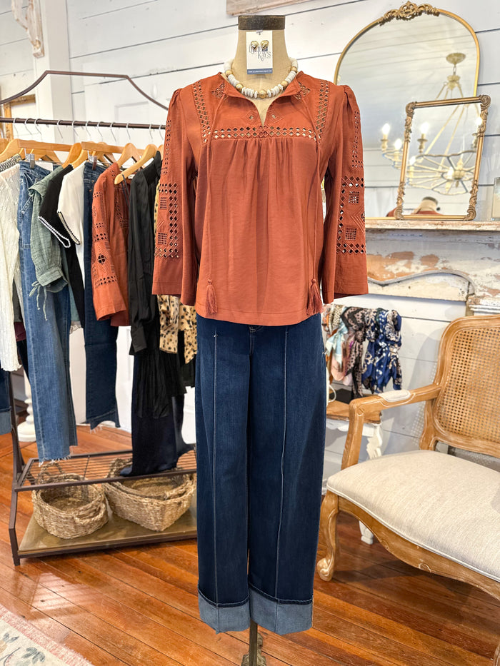 Mannequin wearing a rust-colored blouse and blue jeans in a clothing store
another love rust color top.