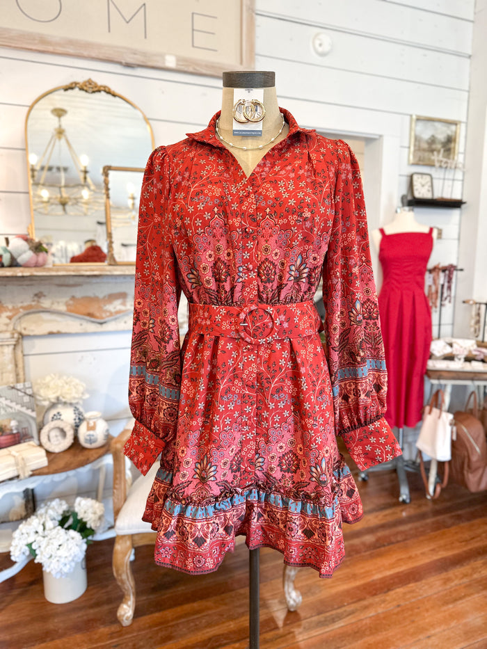 Red patterned dress on a mannequin in a store setting
