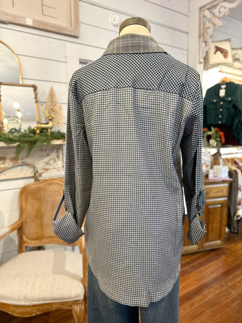 Mannequin wearing a checkered shirt in a store setting with various items in the background.
