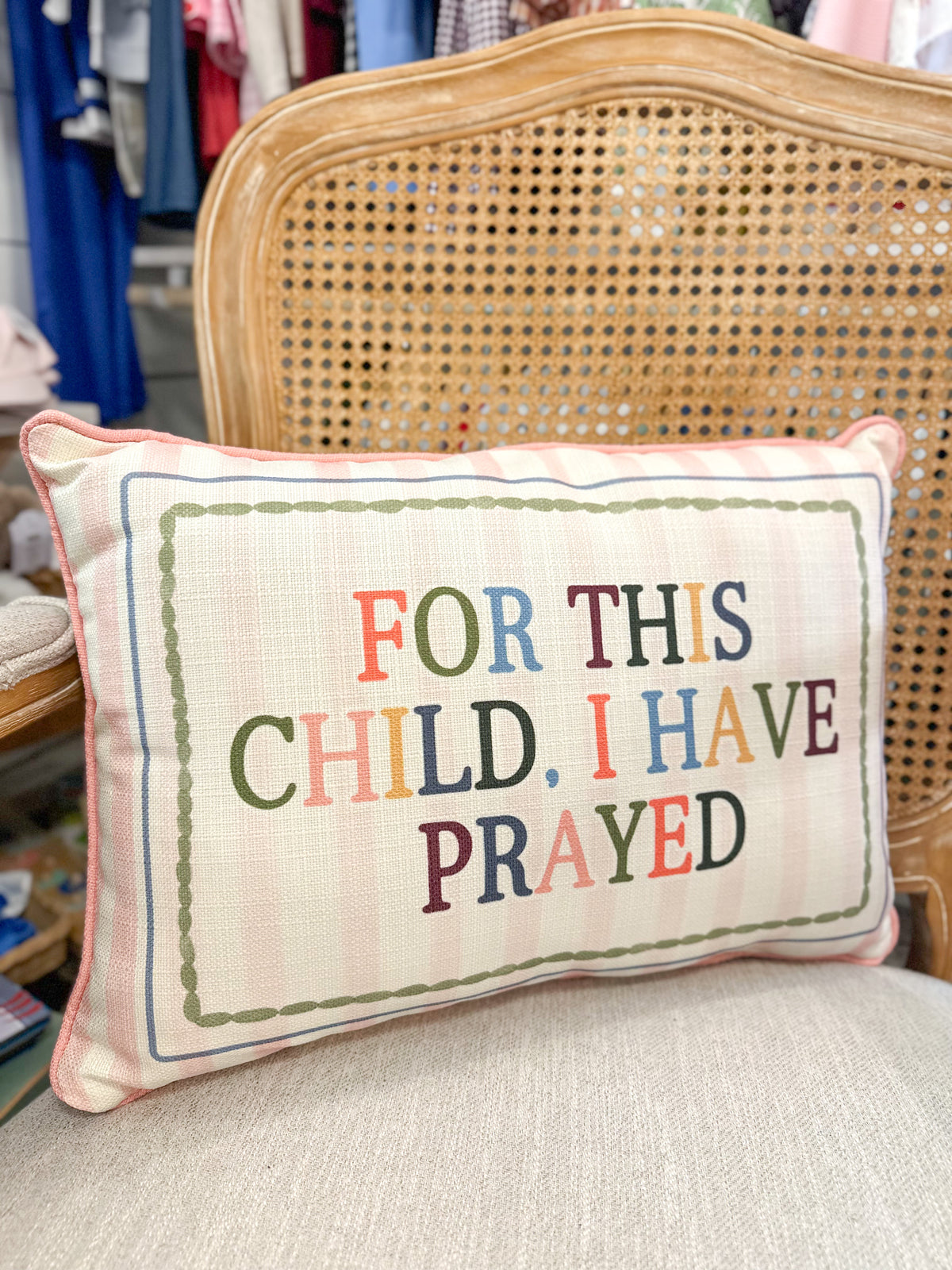 Decorative pillow with colorful text on a chair in a store setting