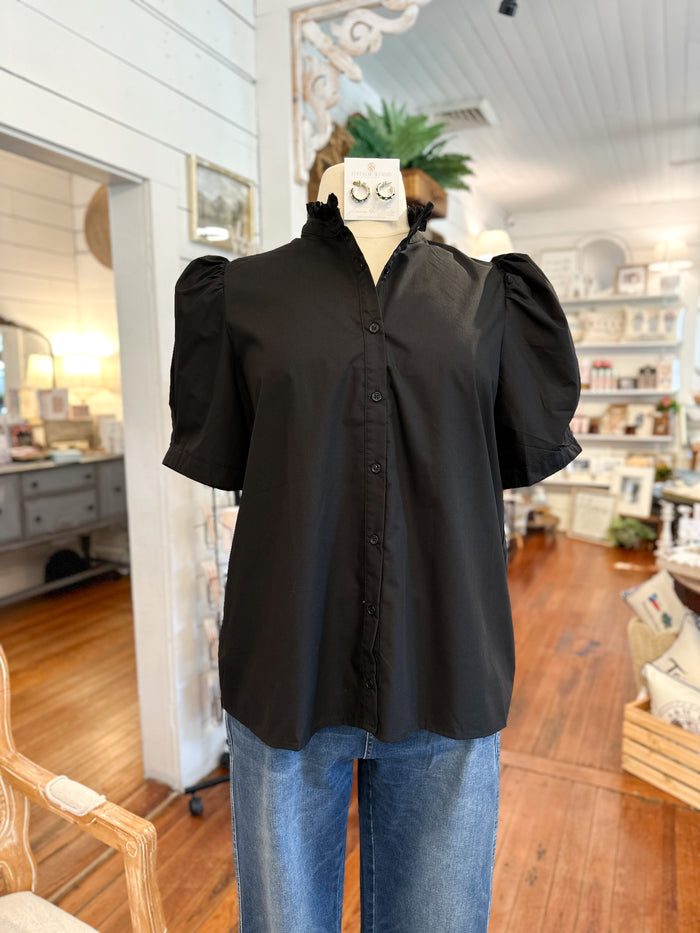 Black blouse on a mannequin with blue jeans in a store setting