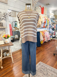 Mannequin wearing a striped sweater and jeans in a store setting