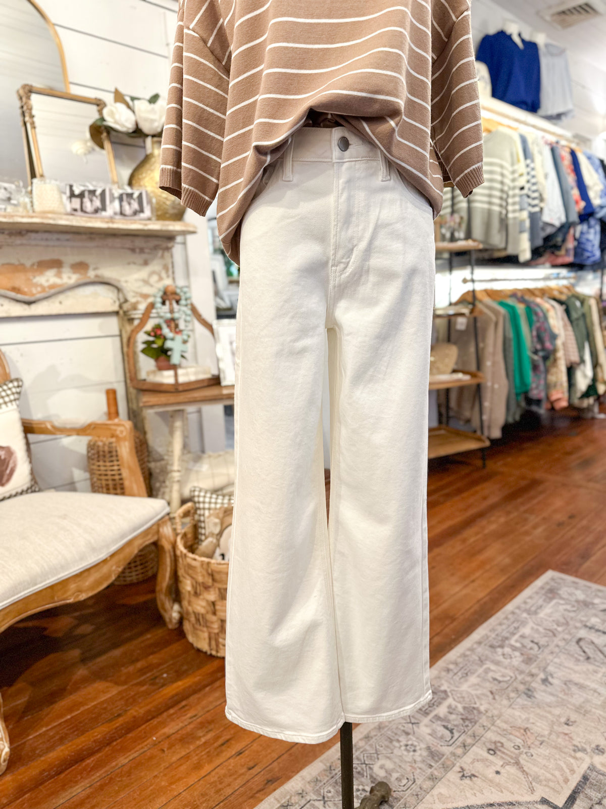 Person wearing a striped shirt and white pants in a store setting