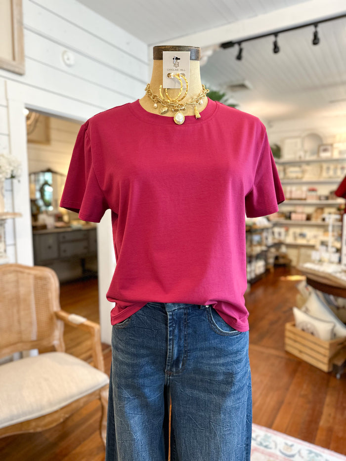 Mannequin wearing an orchid pink t-shirt and blue jeans in a store setting. another love top 