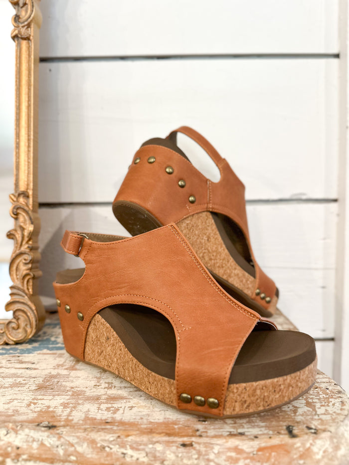 Brown wedge sandals with cork sole on a wooden surface corkys carley wedge