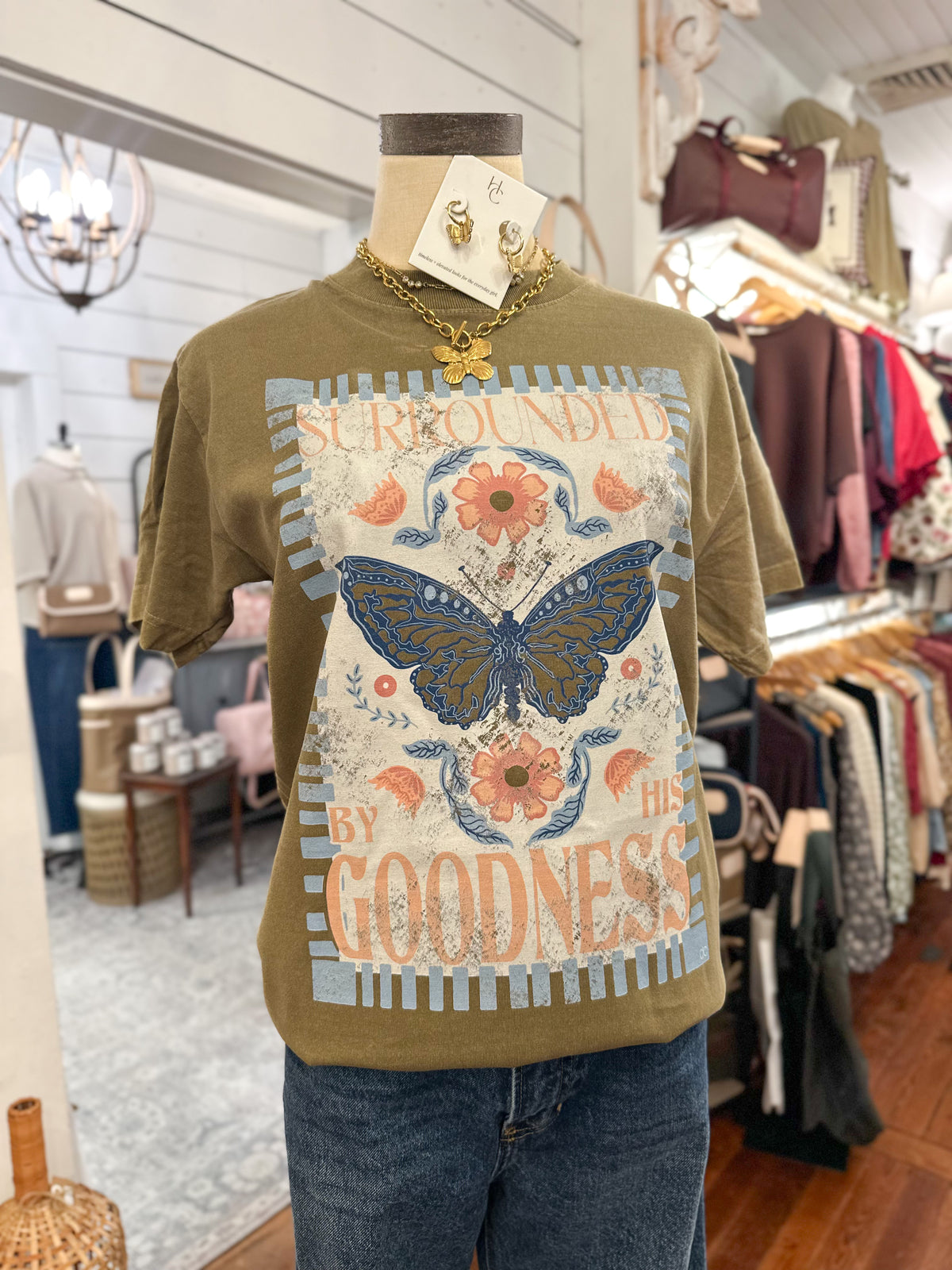 surrounded by his goodness tee on olive green top
