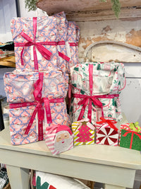 pajama folded up with festive designs and ribbons on a wooden surface.