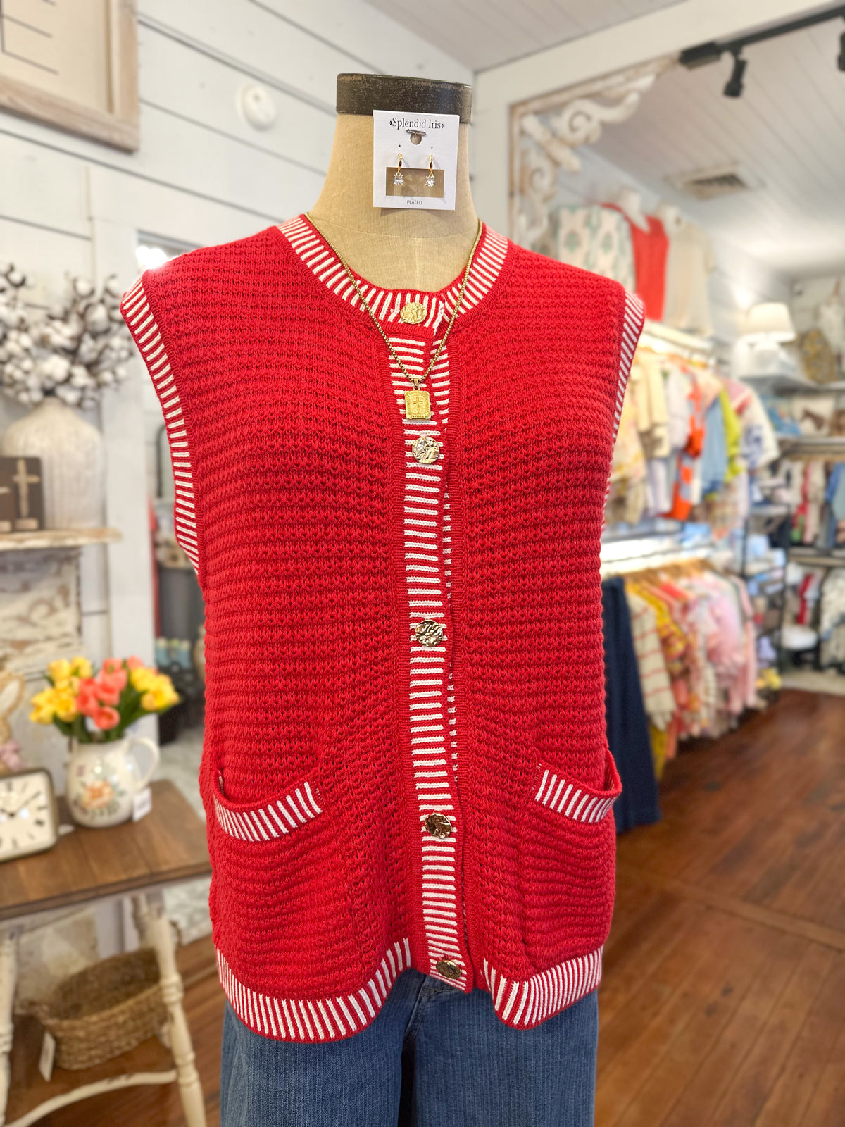 Red knitted vest on a mannequin in a store setting