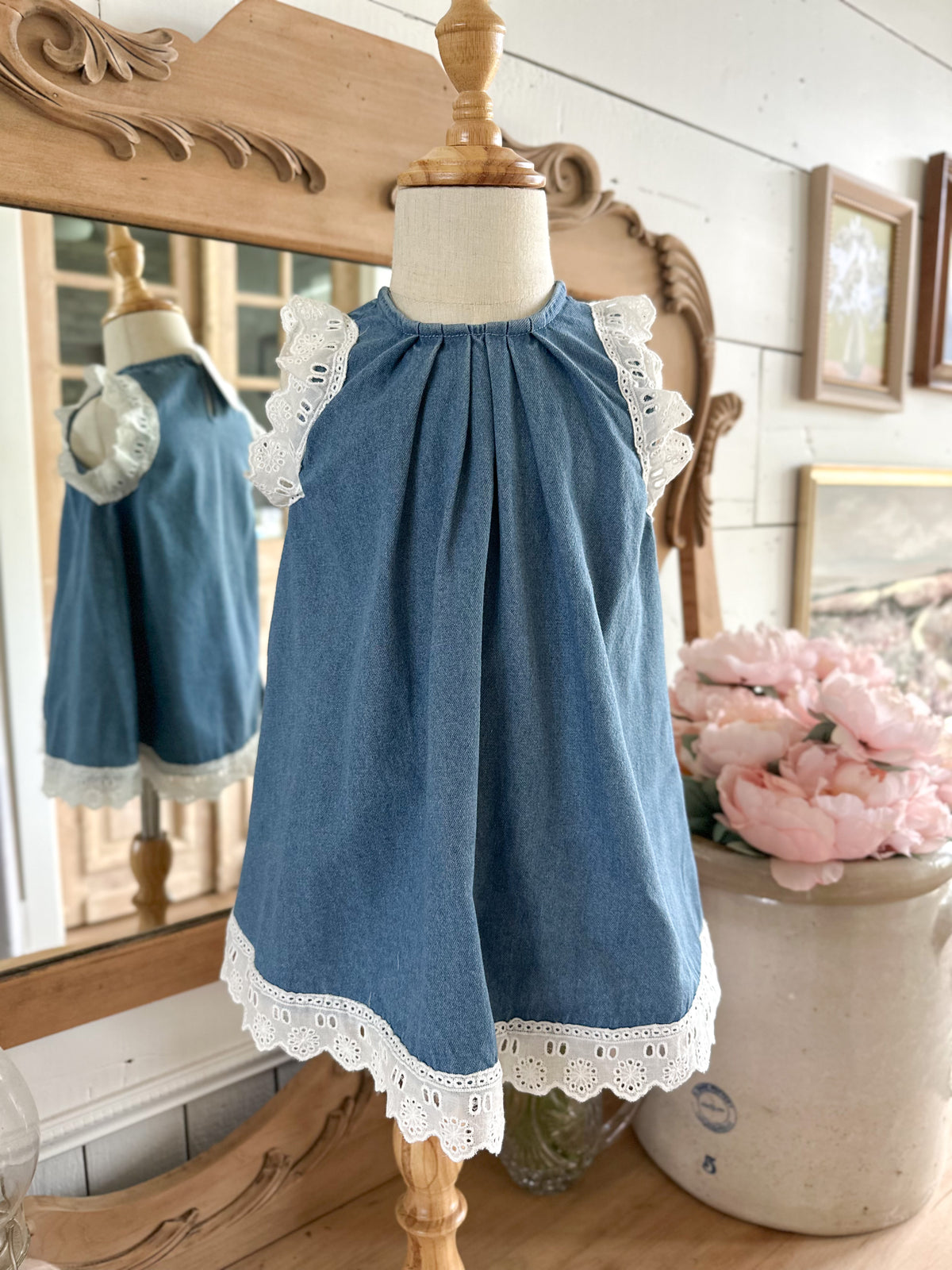 Blue dress with lace trim on a mannequin in a decorative setting. toddler and youth sizes