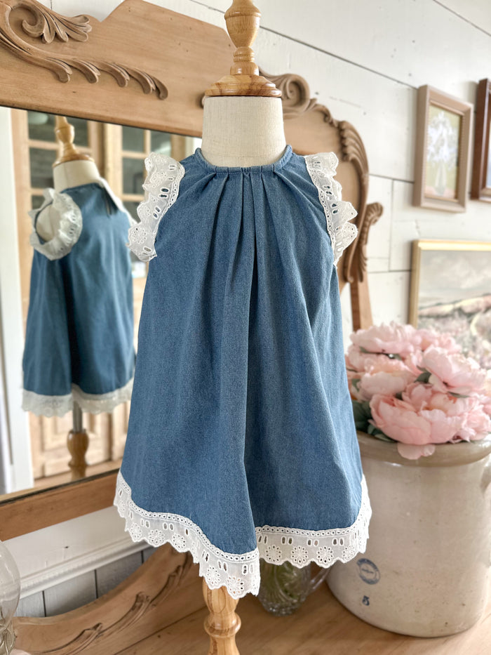 Blue dress with lace trim on a mannequin in a decorative setting. toddler and youth sizes