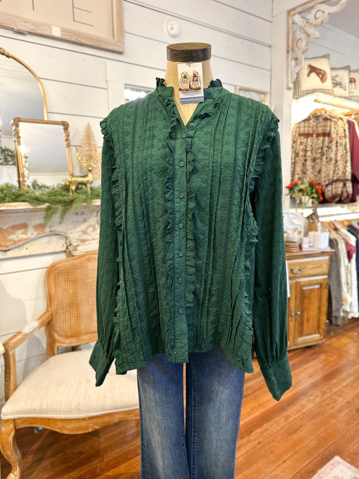 Green blouse on a mannequin in a store setting with wooden floors and furniture. layerz clothing kathleen blouse 
