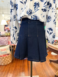 Navy blue skirt on a mannequin with a floral-patterned shirt in a store setting.