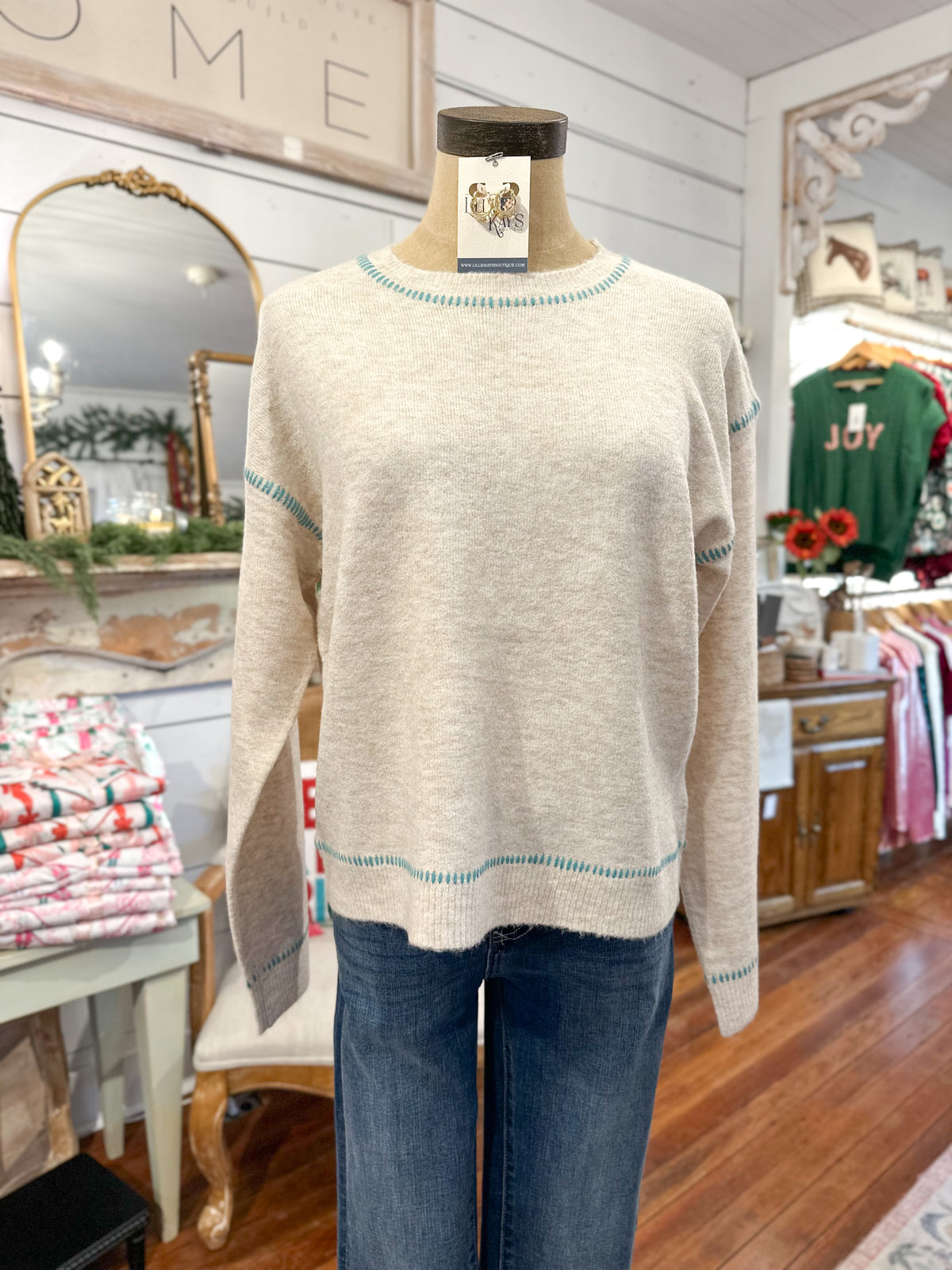 Beige sweater on a mannequin with a tag in a store setting