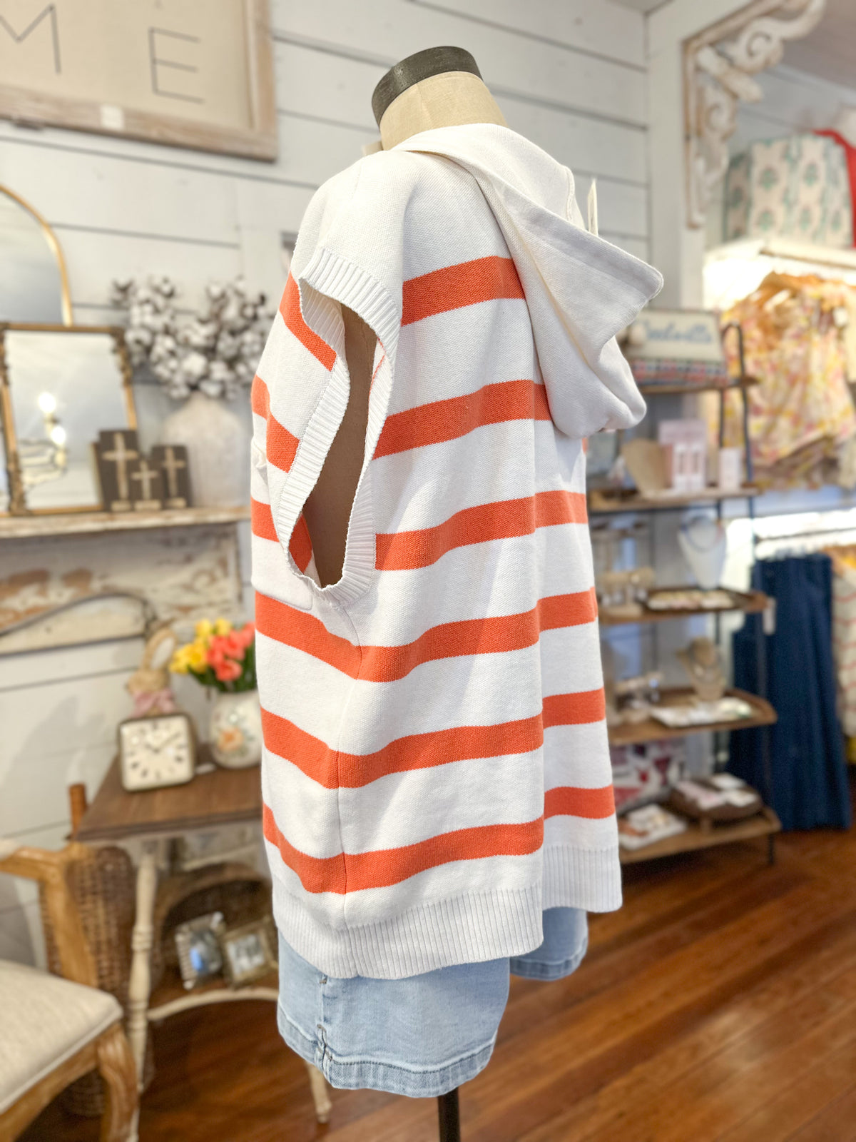 Mannequin wearing a striped sweater with a hooded top in a store setting
