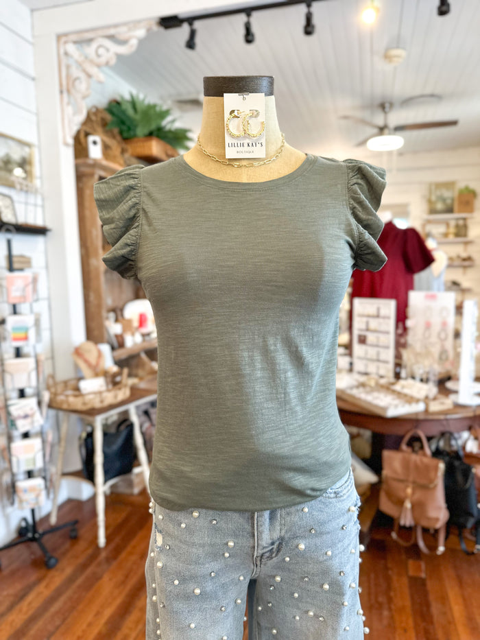 Green top on a mannequin with a blurred store interior background
another love north top in slate green and jewelry 