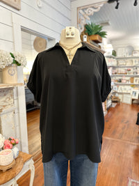 Black shirt on a mannequin with blue jeans in a store setting