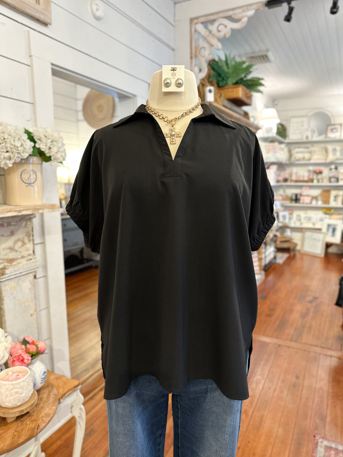 Black shirt on a mannequin with blue jeans in a store setting