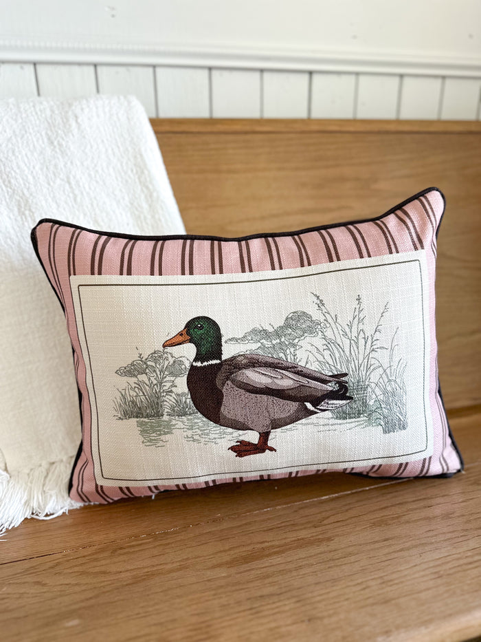 Decorative pillow with a duck illustration on a wooden surface